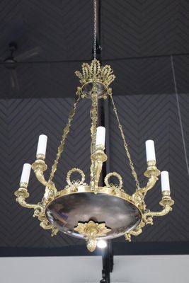 un lustre ancien en laiton suspendu au plafond, orné de bougies