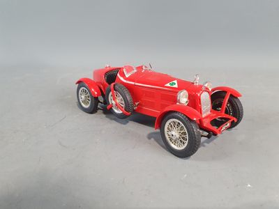 a red toy car that is sitting on a gray surface