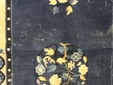 an old rug with yellow and blue flowers on a black background