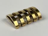 brass plated ring with four rows of rings on a white surface