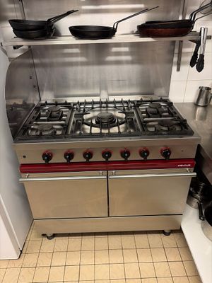 a stainless steel stove top in a kitchen with pots and pans on it