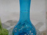trois vases de couleurs différentes posés sur une surface blanche
