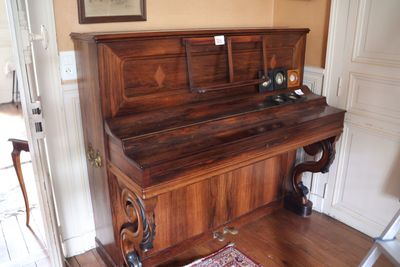 un piano dans un coin d'une pièce où se trouve un tapis au sol