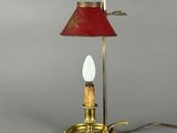 une lampe de table en laiton surmontée d'un abat-jour rouge