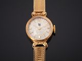 gros plan d'une montre en or sur une surface noire