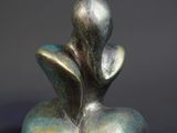 a sculpture of a bird made of metal on a black background