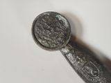 a silver spoon with a silver handle on a white surface