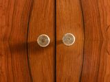 a close up of a wooden cabinet with two knobs