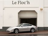 a silver car parked in front of a white building
