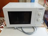 un micro-ondes blanc posé sur une table