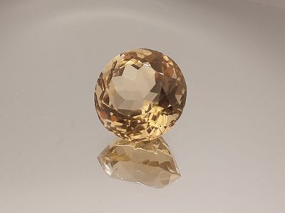 an image of a yellow topazte gems sits on a white surface