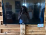 un téléviseur posé sur une palette en bois, avec une personne en train de prendre une photo