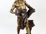 une statue en bronze représentant un homme tenant un seau d'eau