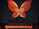 a bed with a butterfly headboard on it in a room