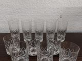 six verres posés sur une table, avec un mur blanc en arrière-plan
