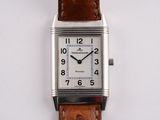 une montre en argent avec un bracelet en cuir marron sur un fond blanc
