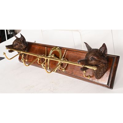 two cats that are sitting on a coat rack