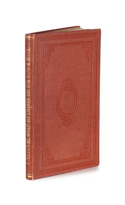 un vieux livre à la couverture rouge posé sur une surface blanche