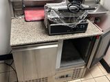 une petite cuisine avec une cuisinière et un micro-ondes posés sur le plan de travail