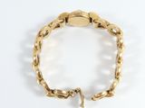 a close up of a gold bracelet on a white surface