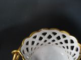 a white bowl with a gold handle and a white bowl with a gold handle
