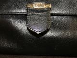 black leather purse with a gold clasp on the front