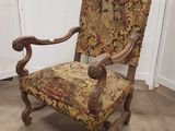 une vieille chaise dont l'assise est recouverte d'un tissu à motifs floraux, dans une pièce