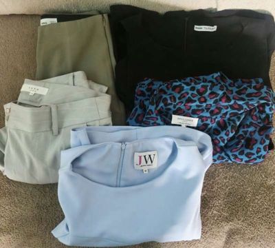 four pairs of men ' s shirts and pants laid out on the floor