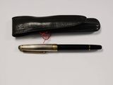 a black pen and a black case on a white surface