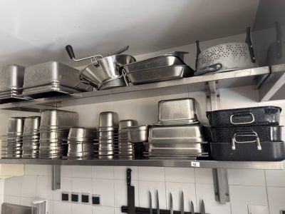 many pots and pans on the shelves in the kitchen