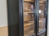 a black cabinet with glass doors in a room