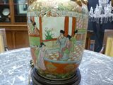 a vase that is sitting on a table with a chandelier in the background