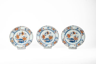 trois assiettes bleues et blanches ornées de fleurs orange