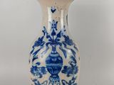 un vase bleu et blanc posé sur une surface blanche