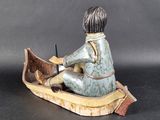 a figurine of a boy in a boat on a table