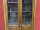 a large wooden cabinet with glass doors on it