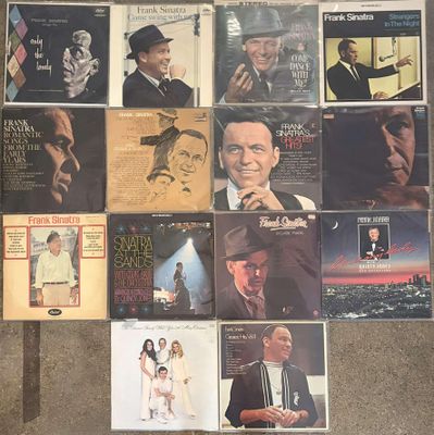 many different album covers on the wall of a room