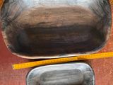 two metal bowls sitting on top of a wooden table