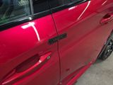 a red car that has a sticker on the side of it