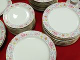a lot of plates that are sitting on a red table