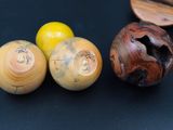 three wooden bowls and two wooden spoons on a black surface