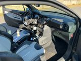 l'intérieur d'une voiture, la portière ouverte, avec le volant et le tableau de bord visibles