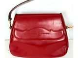 sac à main en cuir rouge avec une poignée et une bandoulière, sur fond blanc