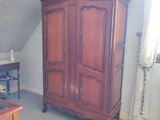 un grand meuble en bois dans le coin d'une pièce