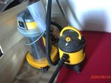 a yellow and black vacuum sitting on a red mat