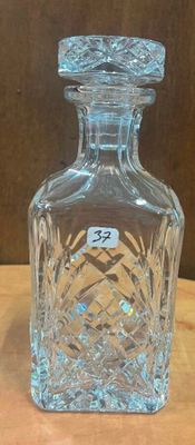 une bouteille en verre transparent posée sur une table en bois