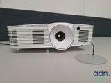 a white projector sitting on a table with a mouse