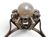 an image of a white pearl and diamond ring on a white background