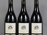 trois bouteilles de vin sont alignées sur une table
