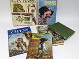 quatre livres posés sur une table blanche, avec un chien et un livre